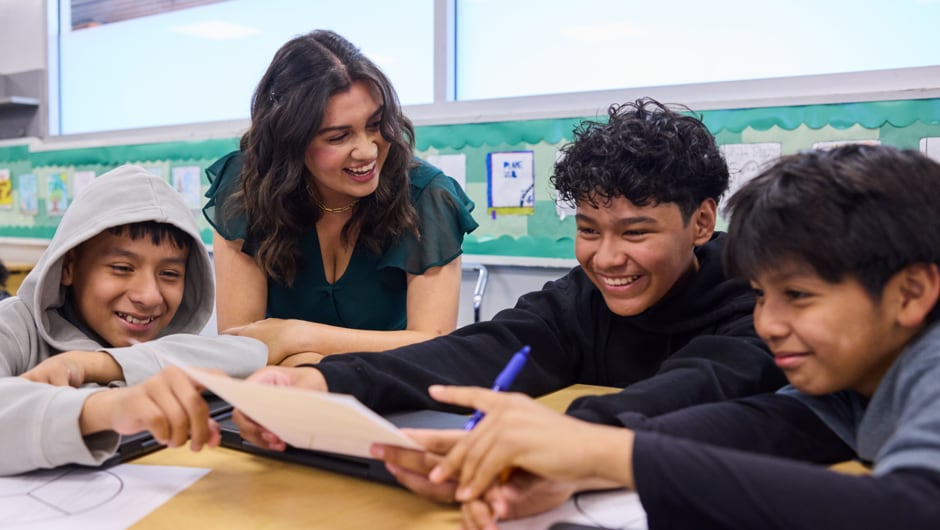 teacher interacting with students while smiling