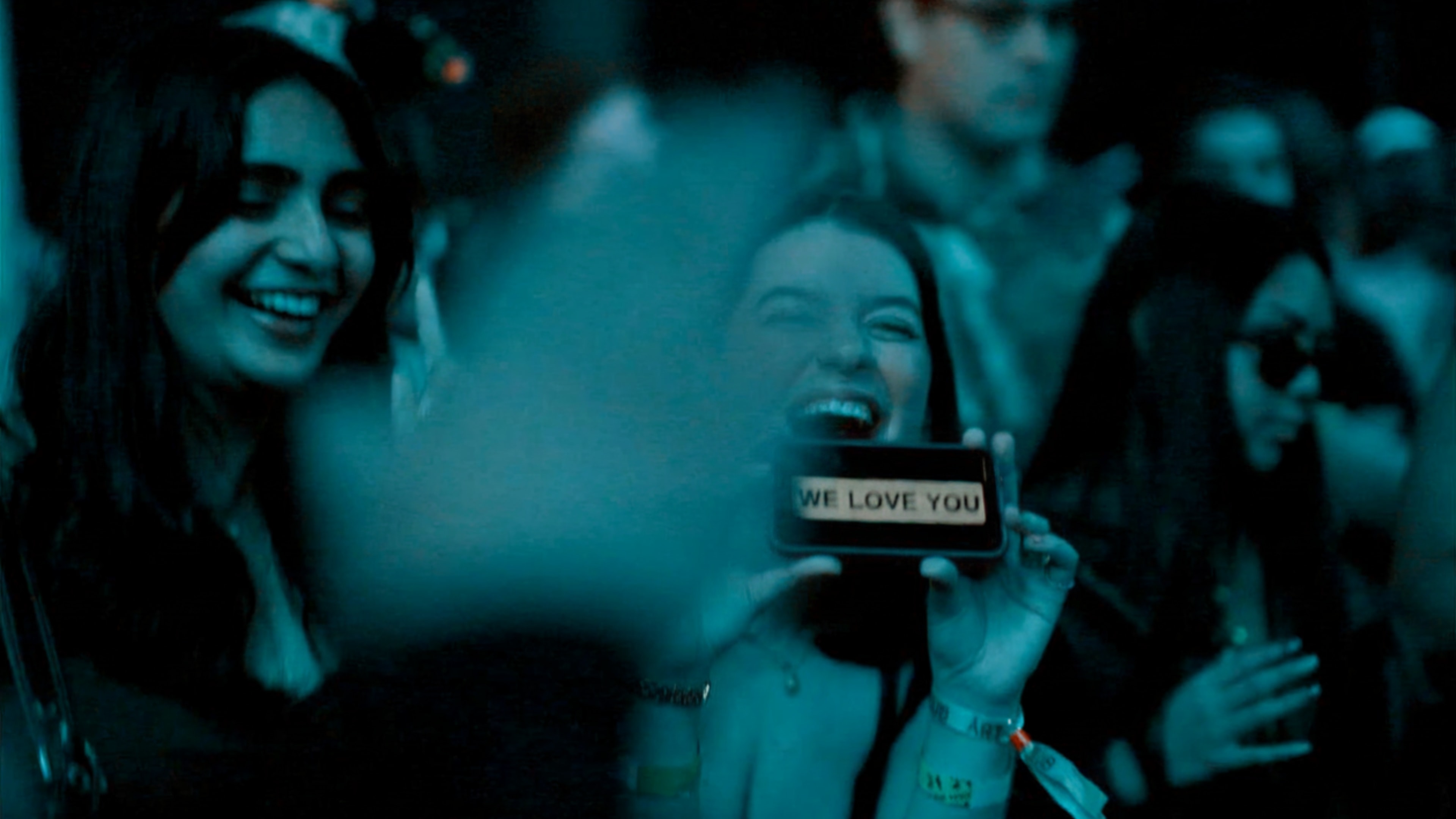 Concert goers hold a phone saying I love you