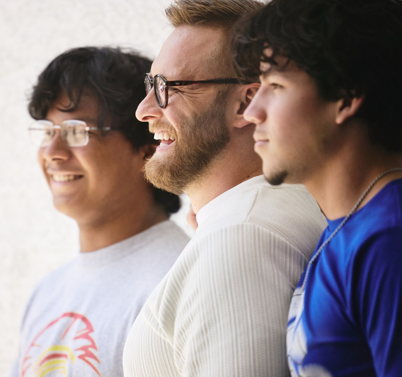 A teacher smiles with their students.