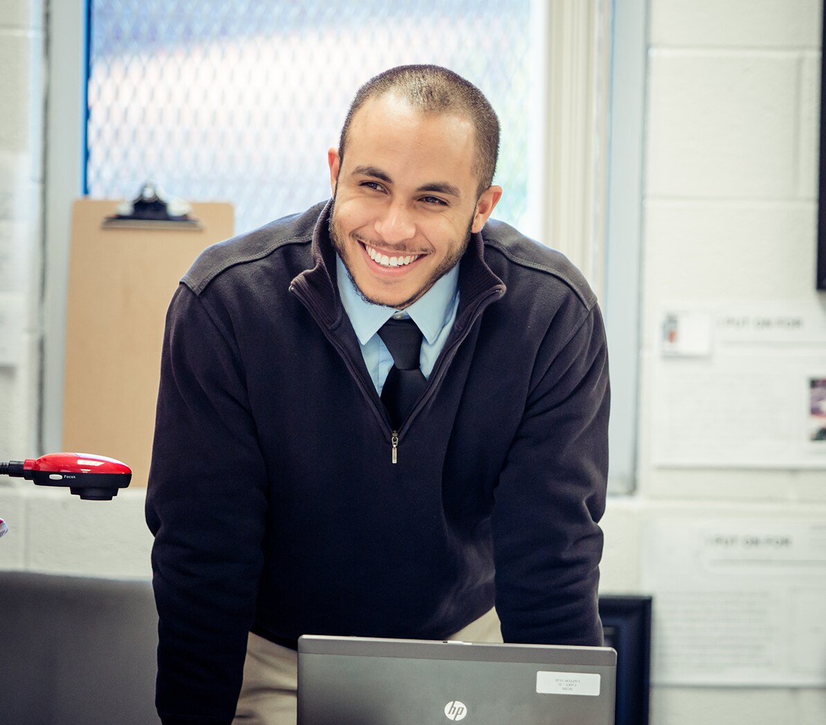 A teacher leans over a desk.