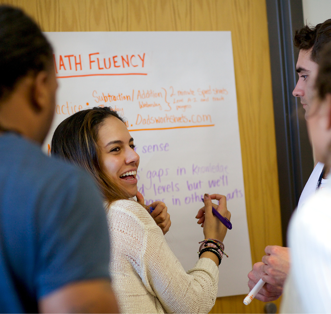 Recruiters collaborating around a white board.