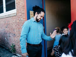 Sergio Santiago greets students walking into school. 