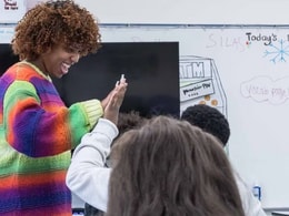 Alt text: A teacher high fives a student