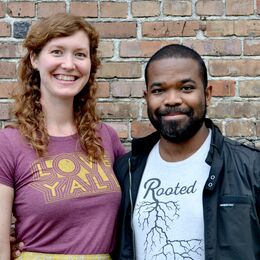 smiling woman standing next to smiling man 