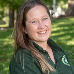 Smiling woman with arms crossed and green shirt