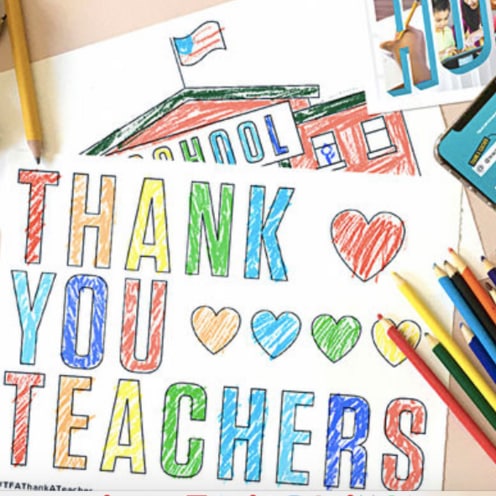 A desk with colored pencils and a drawing that states "Thank you teachers"