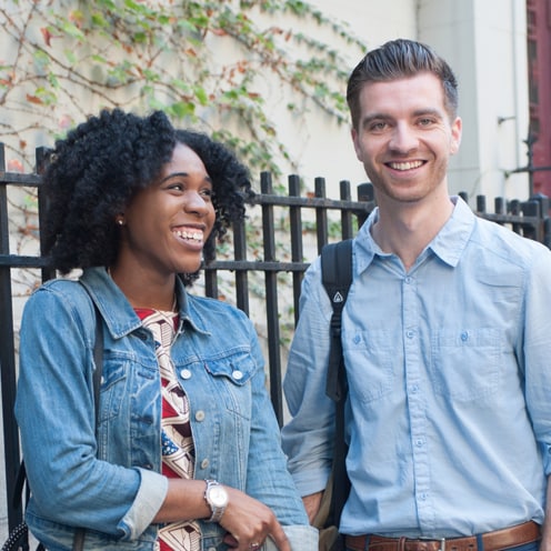 Two teachers in conversation, smiling.