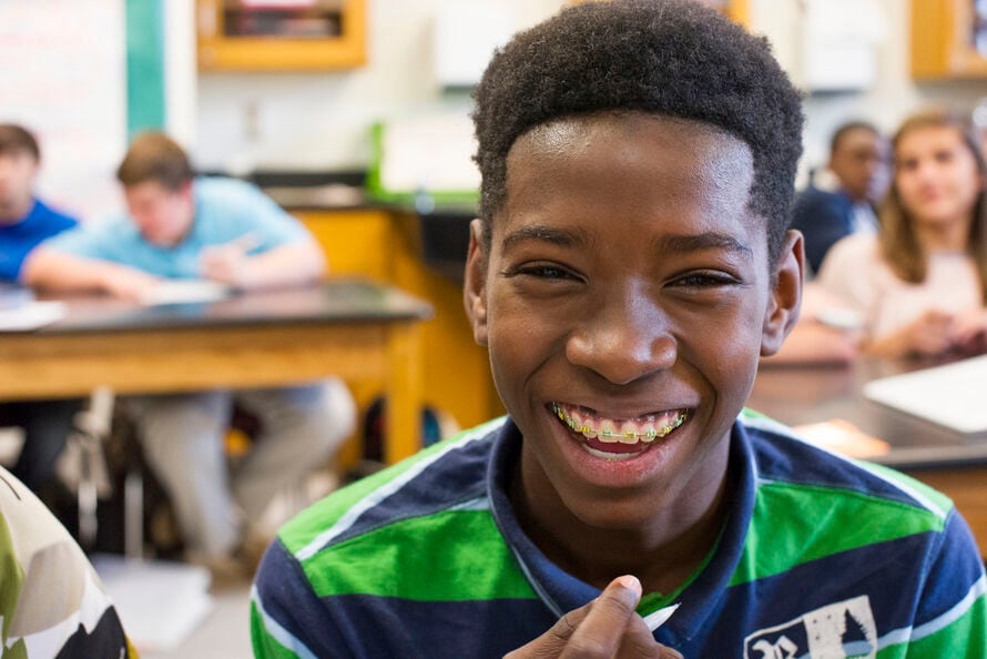 Alt text: a student smiles in a classroom