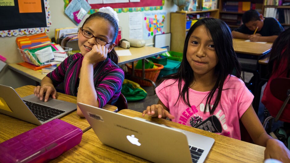 Students working on laptops at their desks.