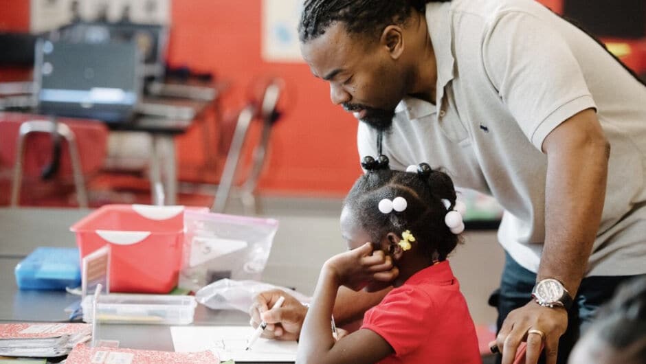 Kenneth Robinson helps a young child with a drawing project