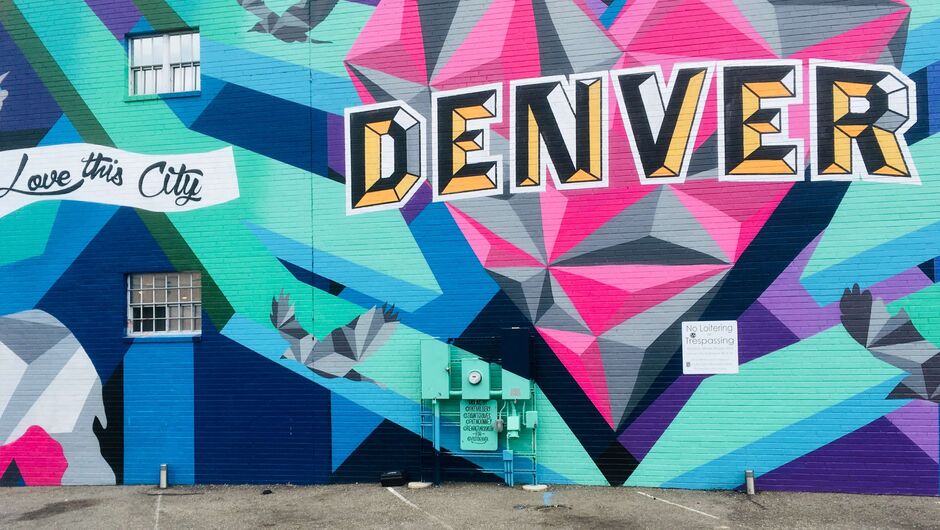 A wall is painted in bright colors with the word Denver. 