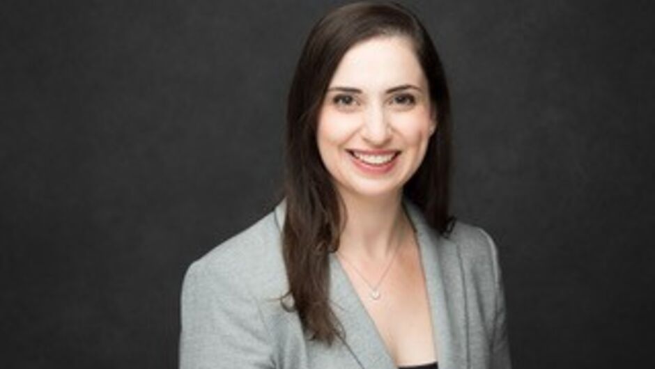 Alt text: A woman in a gray blazer