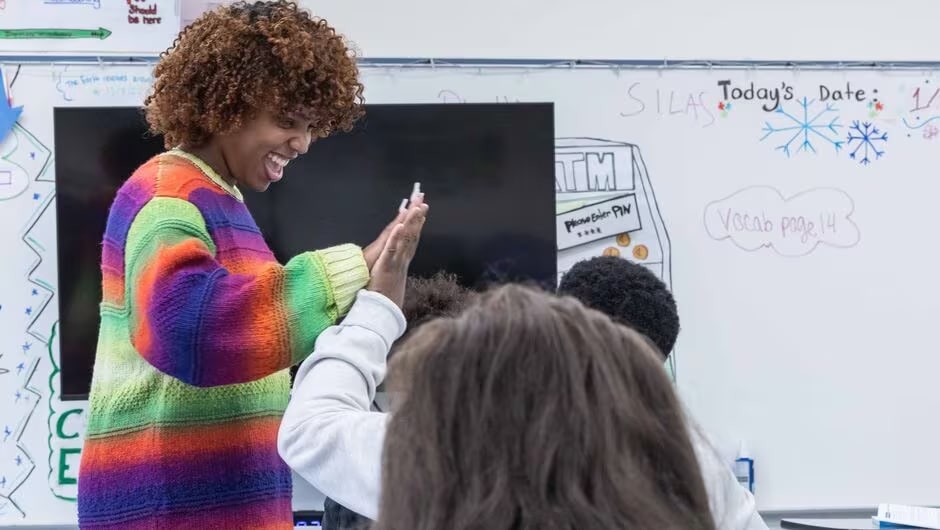 A teacher high fives a student