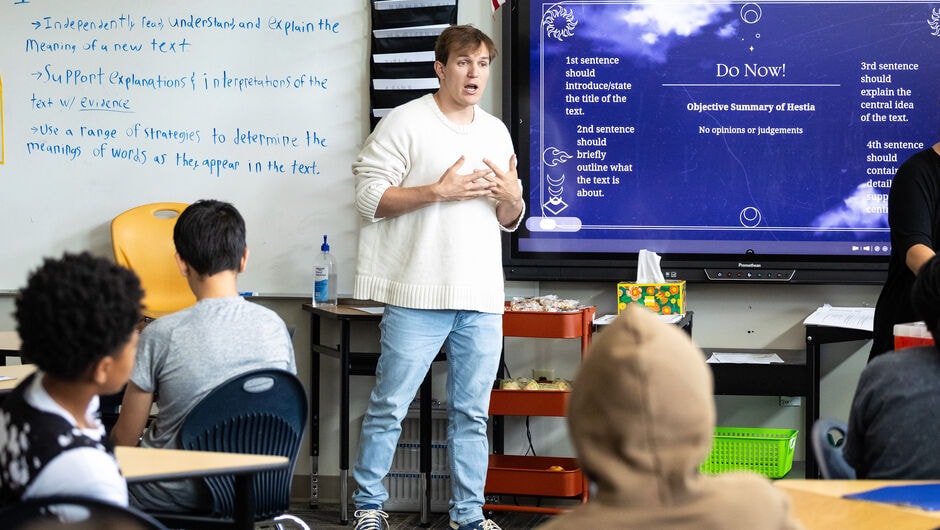 A teacher presents in front of students in a classroom.