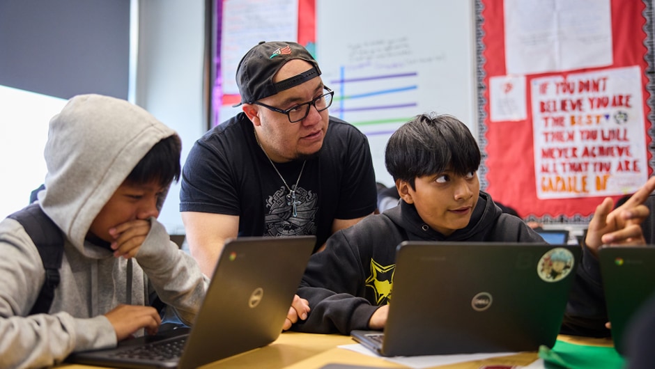 A teacher works with students in the classroom.