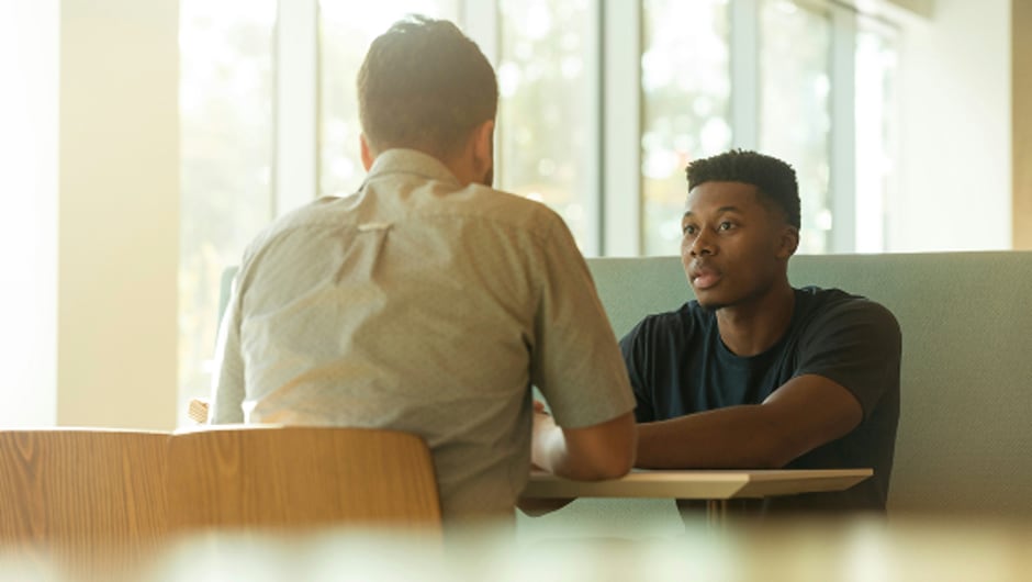 Two men seated across from one another at a table