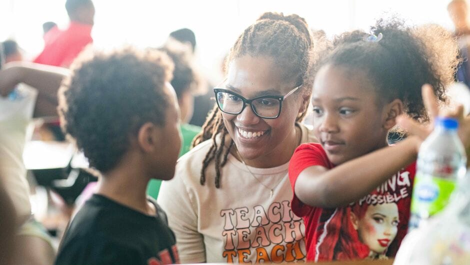 A teacher working with young students.
