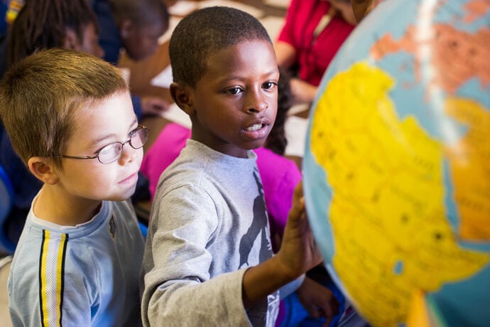 Students looking at a globe.