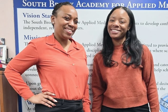 Dr. Roshone Ault Lee (left) and Deja Senghor (right) standing next to each other wearing red shirts