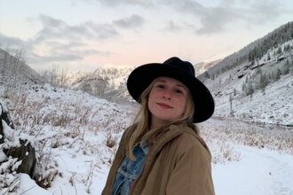 Picture of white woman with blond hair wearing a hat on a snowy day