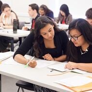 Teacher working with student at desk.