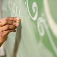 Teacher writing on the chalkboard. 