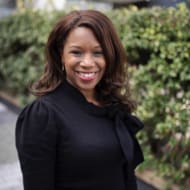 Women with brown hair wearing a black suit