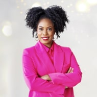 Charli Cooksey in a bright pink blazer standing in front of a white, sparkly background