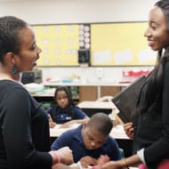 Two Black women stand in front of the classroom.