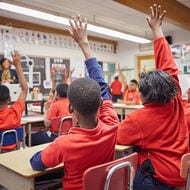 students with hands raised